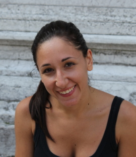 Ritratto di Renata Carnevale, sorridente, davanti a un muro di pietra